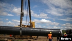 Рабочие устанавливают трубу на строительной площадке газопровода «Турецкий поток» перед визитом президента Сербии Александра Вучича и премьер-министра Болгарии Бойко Борисова в Летницу, Болгария, 1 июня 2020 года