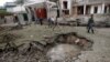 Afghan policemen walk past a crater at the site of a suicide attack at the Indian Consulate in Jalalabad on August 3. 