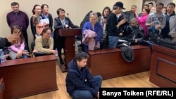 Сот өтінішін қанағаттандырмаған соң Әлімжан Ізбасаров  аштық жариялайтынын айтып, сот залының еденіне отырып алды. Нұр-Сұлтан, 4 мамыр 2019 жыл.