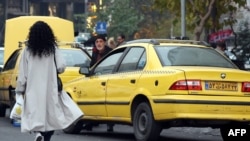 Тыюу салууга карабай Тегерандын көчөсүндө жылаңбаш бараткан аял. 12-декабрь, 2024-жыл. 