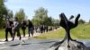 Members of Croatia's Jewish community walk past a memorial in the shape of a flower at Jasenovac in April 2016.