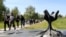 Members of Croatia's Jewish community walk past a memorial in the shape of a flower at Jasenovac in April 2016.