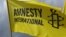 Amnesty International эл аралык уюмунун эн белгиси тартылган желек