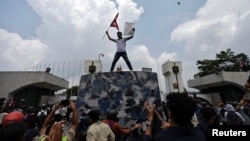 Дэманстрант са сьцягам на ​​даху аўтамабіля каля ўваходу ў парлямэнт падчас пратэсту супраць карупцыі і рашэньня ўраду заблякаваць некалькі плятформаў сацыяльных сетак у Катманду, Нэпал, 8 верасьня 2025