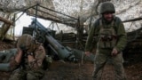 FILE PHOTO: Ukrainian servicemen fire a self-propelled howitzer towards Russian troops near the frontline town of Pokrovsk