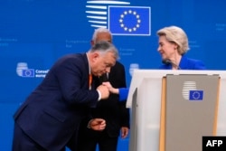 Віктор Орбан нахиляється, щоб поцілувати руку президентці Єврокомісії Урсулі фон дер Ляєн. Але свою опозицію до євроінтеграції України, незважаючи на позицію Брюсселю, наразі не знімає