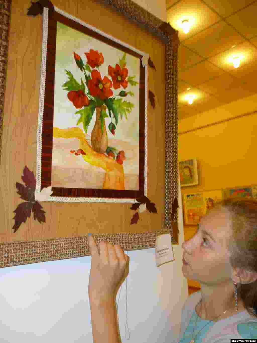 Участница экспериментальной выставки Софья Рыжкова показывает свою картину &laquo;Маки для мамы&raquo;, выполненную с помощью акварели. На этой выставке Софья представила несколько своих работ.&nbsp;