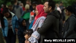 Мусульманская семейная пара стоит через дорогу от мечети в Крайстчерче, где 15 марта этого года были расстреляны десятки мусульман.