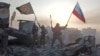 Wagner mercenaries wave flags of Russia and the Wagner Group atop a building in an unidentified location in this still image obtained from a video released on May 20. 
