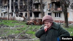 Украинаның Мариуполь шәһәрендә яшәүче хатын Русия хәрбиләре җимергән йорт янында