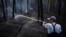 A firefighter extinguishes the remains of a fire in a forest near Yarova in the Holy Mountains National Nature Park in July.