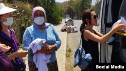 Периза Асаналиева айылдыктарга жардам таратып жатат.