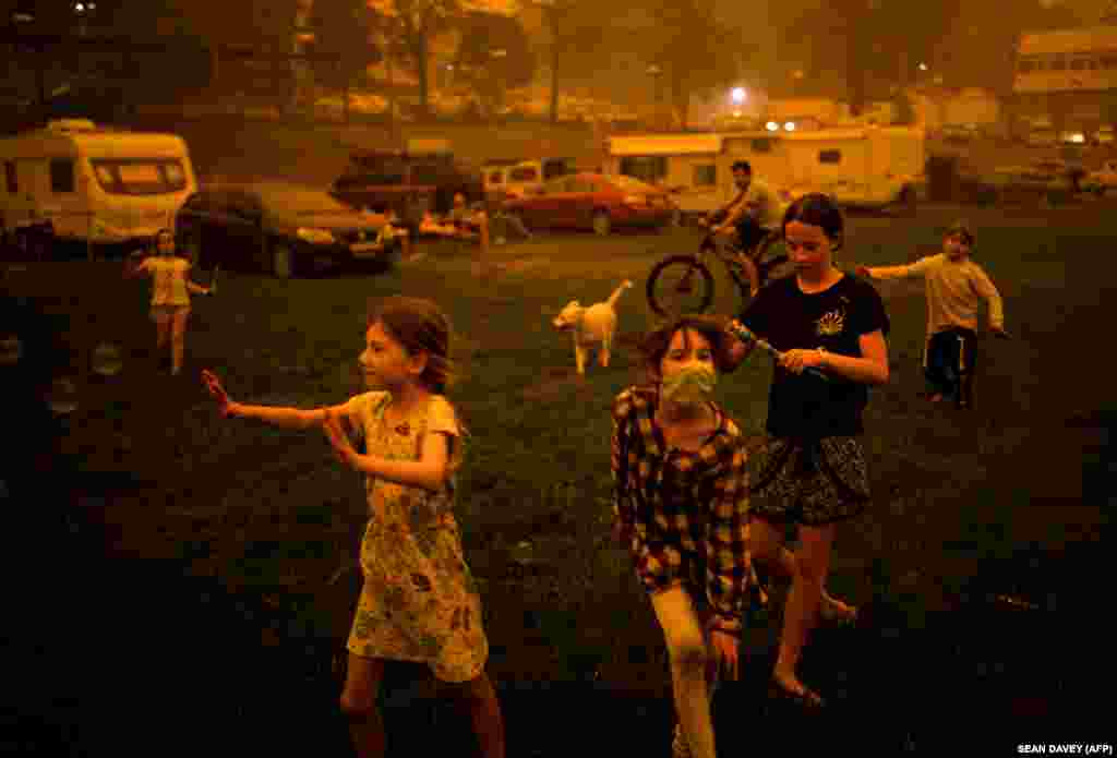 Дети играют на улице погруженного в дым городка в Новом Южном Уэльсе. Это один из самых пострадавших от пожаров штатов. В регионе сгорело около пяти миллионов гектаров леса и 1300 домов. Тысячи людей вынуждены были покинуть свои дома.