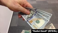 Amerikan dollary we täjik somonisi.