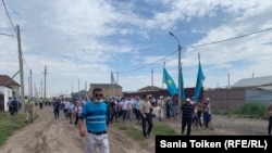 Приехавшие на поминки по Дулату Агадилу люди идут на кладбище, где он похоронен. Село Талапкер Акмолинской области, 8 августа 2020 года.