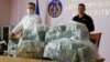 Klymenko's predecessor, Nazar Kholodnytskiy (left) leads a briefing next to $6 million in plastic bags in June 2020, two months before he resigned amid allegations that he helped officials suspected of corruption evade prosecution.