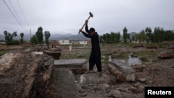 Мальчик-подросток откалывает кувалдой куски бетона фундамента виллы, где укрывался Усама бен Ладен. Абботтабад, 22 апреля 2012 года.