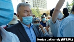 Председатель общественного совета Алматы Рахман Алшанов призывает разойтись людей, вышедших на мирный митинг. 6 июня 2020 года.