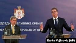 Serbian President Aleksandar Vucic (right) speaks at a press conference after talks with EU Enlargement Commissioner Johannes Hahn (left) in Belgrade on February 7.
