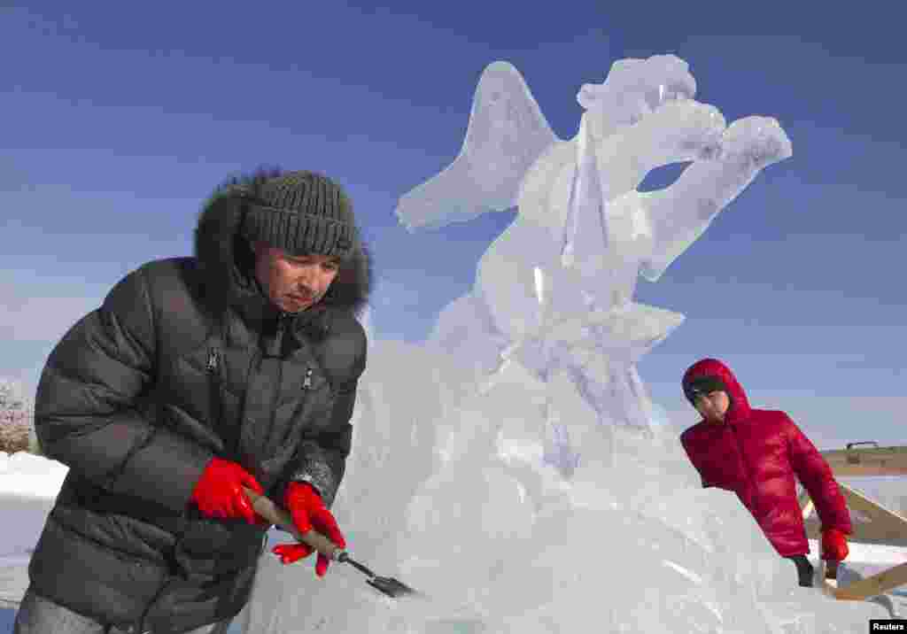 Мастера во время работы над творением изо льда.
