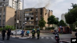 Дим піднімається над будівлею, ураженою ракетою, випущеною з Гази, у Тель-Авіві, Ізраїль, жовтень 2023 року 