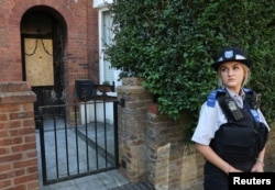 Поліцейська стоїть біля приватного будинку Стармера після пожежі, 13 травня 2025 року