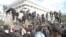 Люди пытаются перелезть через ограду здания парламента. Бишкек, 3 октября 2012 года.
