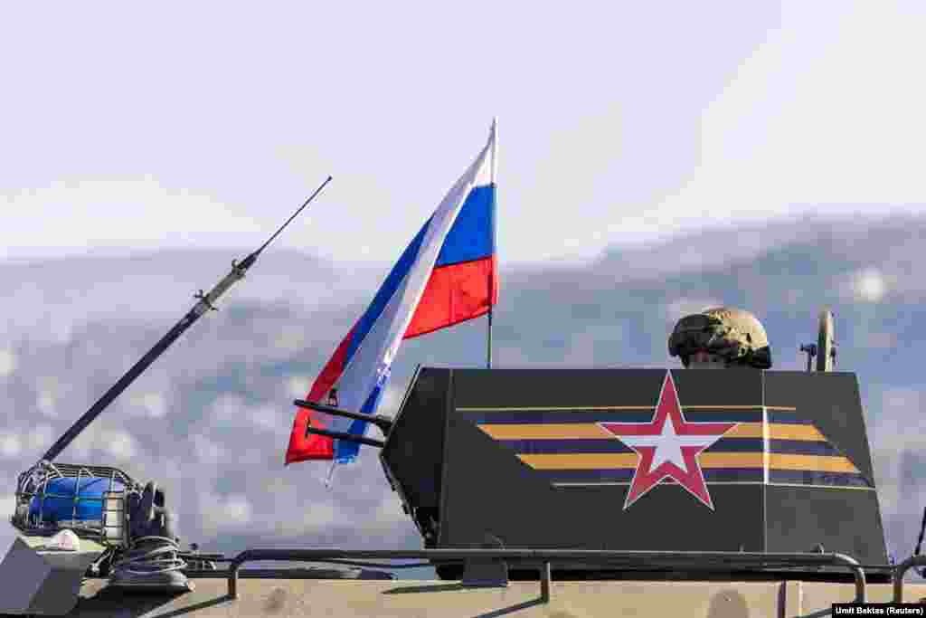 Російський стрілець на башті бронемашини на під&#39;їзді до авіабази Хмеймім.&nbsp; &laquo;Спілкуватися із російськими солдатами неможливо&raquo;, &ndash; розповідає фотограф Бектас.&nbsp; &laquo;Вони не відповідають на запитання і не підпускають до себе близько. Вони мають напружений вигляд, але не злий, вони не застосовують жодного насильства або чогось подібного&raquo;, &ndash; додає він. &ndash; &laquo;Вони зберігають холоднокровність&raquo; &nbsp;