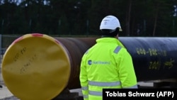 Мужчина работает на строительной площадке так называемого газопровода «Северный поток — 2» в Любмине, северо-восток Германии, 26 марта 2019 года.