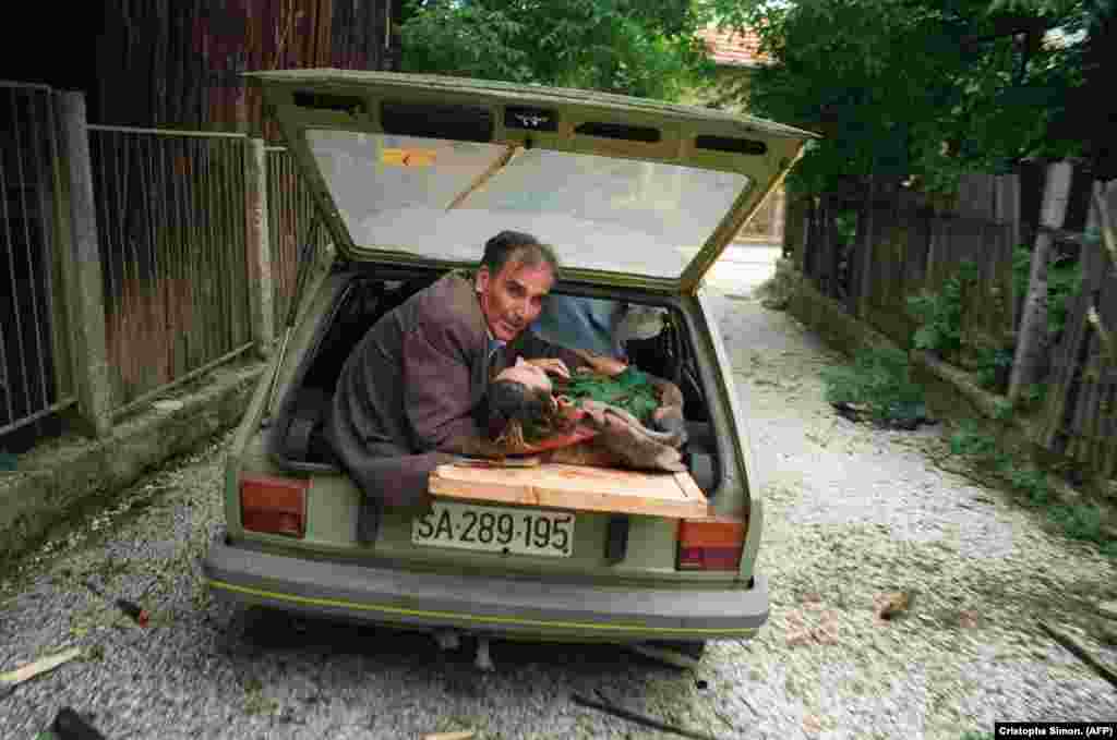 Saraýewo topa tutulanda agyr ýaralanan aýala kömek edýän adam. 27-nji iýun, 1992.&nbsp;