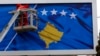 A worker fixes the national flag of Kosovo to a billboard ahead of Kosovo's fifth anniversary of its independence in Pristina in February 2013.