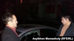 Активист Жанболат Мамай (справа) заявляет, что его машина была преднамеренно повреждена, Алматы, 6 декабря 2016 года. 