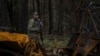 A Ukrainian serviceman walks along a road while searching for dead bodies of his comrades killed in the recently recaptured town of Lyman on October 3. 