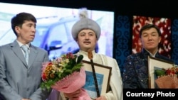 Акыны стоят на сцене после завершения айтыса в Астане 13 декабря 2010 года.