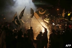 Толпа размахивает пакистанскими национальными флагами, празднуя объявление о прекращении огня между Пакистаном и Индией. Город Хайдарабад, провинция Синд. 10 мая 2025 года