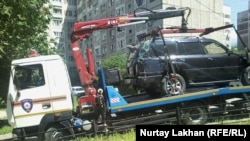 Автомобиль эвакуируют с территории, прилегающей к детскому саду. В результате наезда погиб один ребенок, несколько госпитализированы с травмами. Алматы, 20 мая 2015 года.