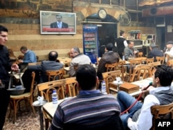 Ассаддын кайрылуусун кафеде көрүп жаткан сириялыктар.