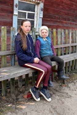 Дарина і Артем біля своєї хати, яка дивом уціліла. Село Острови. 20 квітня 2020 року