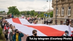 Warşawada ýüzlerçe demonstrant Belarus oppozisiýasynyň gyzyl we ak baýdagyny galdyrdy.