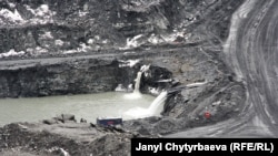 Карьерге топтолгон сууну насостор менен анын сол тарабындагы аңга тартып чыгарышууда