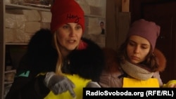 Волонтер організації «Жизнелюб» Олена роздає (ліворуч) обіди людям