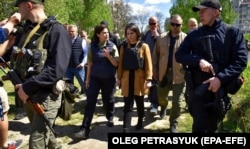 Міністр закордонних справ Німеччини Анналена Бербок (праворуч) і генеральний прокурор України Ірина Венедіктова розмовляють біля місця братської могили в місті Бучі, що на Київщині, 10 травня 2022 року