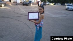 Кызым Сезим 7-июнда "Азаттыктын" 60 жылдык мааракесинде мага берилген дипломду кармап турат