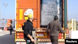 Керем Шалом бекетиндеги гуманитардык жүк ташыган унаалар.