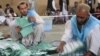 Afghan workers of the Afghan Independent Election Commission (IEC) count presidential ballots on April 5 at a polling station in Kandahar.