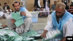 Afghan workers of the Afghan Independent Election Commission (IEC) count presidential ballots on April 5 at a polling station in Kandahar.