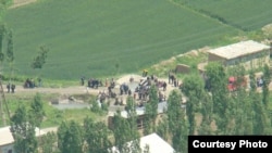 Сохтун Хушяр айылынын тургундары чек арага топтолууда, 2010-жылдын 28-майы.(Суу бойлоп кеткен жолдун берки тарабы Кыргызстандын аймагы.) 