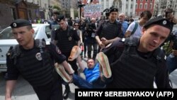 Гей белсенді Николай Алексеевті Ресей арнайы жасағы көтеріп бара жатыр. Мәскеу, 30 мамыр 2015 жыл.  