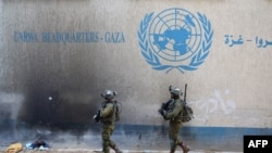UNRWA агенттигинин Газадагы кеңсесинин жанынан өтүп бараткан израил аскерлери. 8-февраль, 2024-жыл.