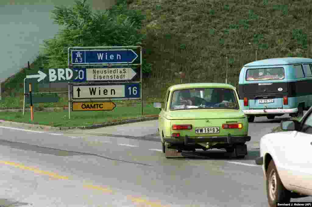 An East German car follows a handwritten sign for West Germany, or&nbsp;Bundesrepublik Deutschland (BRD).